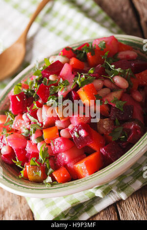 Salade de légumes vinaigrette de betteraves, carottes, haricots, pommes de terre et les oignons dans un bol close-up vertical. Banque D'Images