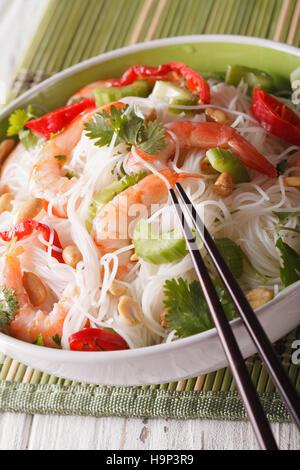 Salade thaï avec des nouilles de verre, de crevettes et d'arachides dans un bol close-up vertical. Banque D'Images