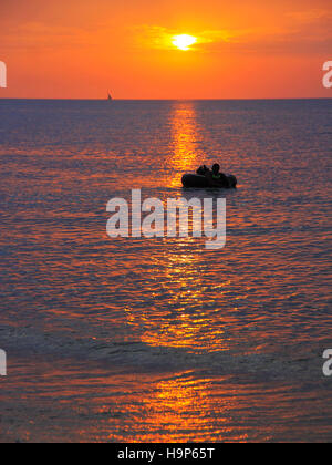 Coucher de soleil sur l'eau sur la plage à l'ancienne ville de pierre de Zanzibar. Banque D'Images