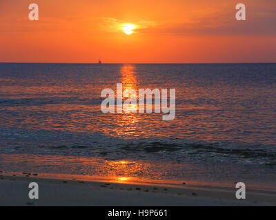 Coucher de soleil sur l'eau sur la plage à l'ancienne ville de pierre de Zanzibar. Banque D'Images