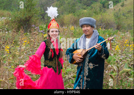 Homme Kazakh dombra chanter et jouer pour une femme, le Kazakh village ethnographique Aul Gunny, Talgar ville, Almaty, Kazakhstan Banque D'Images