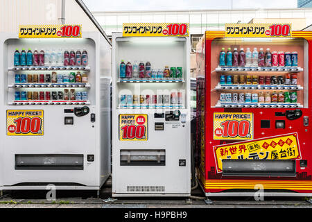 Japon, Osaka, Shinsekai. Trois des distributeurs de boissons, 2 blanc, 1 rouge, en ligne dans la rue. Tous avec des signes montrant : à 100 yen. Vue de face. Banque D'Images
