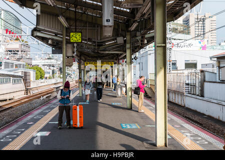 Japon, Osaka, JR Shin-imamiya station sur l'Osaka Loop line. Afficher le long de la plate-forme avec des gens qui attendent pour le prochain train. Banque D'Images