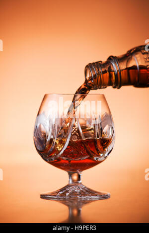 Close up de verser dans un verre de cognac Banque D'Images