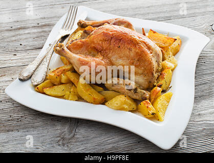 Poulet rôti entier avec des pommes de terre au close up Banque D'Images
