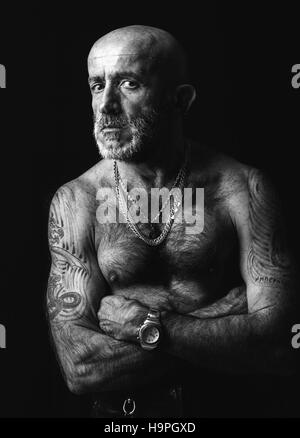 Homme chauve avec mains tatouée en noir et blanc,portrait low key Banque D'Images