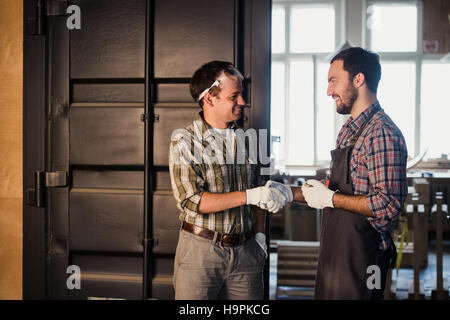 Architectes mâles shaking hands at construction site Banque D'Images