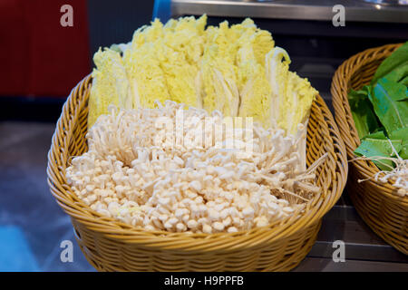 Les champignons enoki types dans le panier Banque D'Images