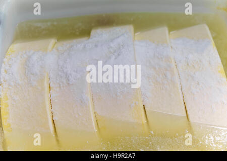 Comte de gruyère fromage jeune dans le bain de sel en Franche Comte dairy en Bourgogne, en France. Banque D'Images