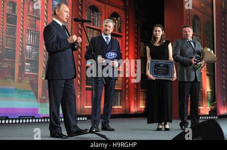 Moscou, Russie. 24 Nov, 2016. Le président russe Vladimir Poutine et l'hôte Valdis Pelsh présente un prix à des documentaristes Olga Stefanova et Alexander Zhukov, au cours de la Société géographique de Russie remise au Kremlin, le 24 novembre 2016 à Moscou, Russie. Les deux ont remporté pour leur film La station de Vostok, sur le seuil de la vie. Credit : Planetpix/Alamy Live News Banque D'Images