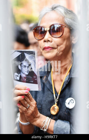 Bangkok, Thaïlande. 26 Nov, 2016. Une femme tient une photo de Thaïlande est tard le roi Bhumibol Adulyadej lors d'un événement tenu au deuil le Chinatown de Bangkok, Thaïlande, le 26 novembre 2016. La Thaïlande a été plongé dans le deuil après la mort du roi Bhumibol, le 13 octobre, avec le deuil et le recueillement événements organisés dans tout le pays pendant une année de deuil. Mangmang Crédit : Li/Xinhua/Alamy Live News Banque D'Images