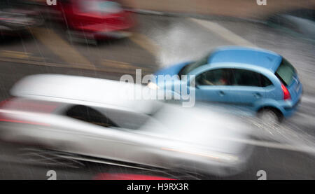 Conduire des voitures dans la rue ville touchée par les fortes pluies de grêle en situation dangereuse avec une faible visibilité et les projections d'eau. Banque D'Images