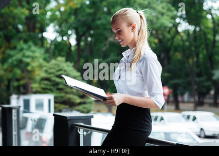 Happy young business woman holding folders et à l'extérieur Banque D'Images