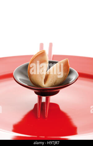 Fortune cookies avec des baguettes sur une plaque rouge Banque D'Images