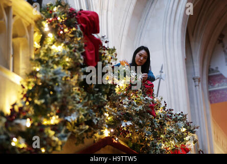Un membre du personnel Royal Collection Trust donne la dernière touche le grand escalier de l'Appartements d'État, dans le cadre de décorations de Noël d'être mis en place au château de Windsor, Berkshire. Banque D'Images