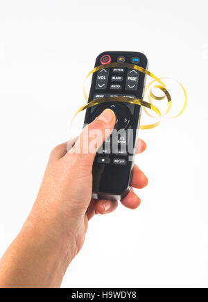Main tenant une télécommande dans un ruban d'or de fête sur fond blanc Banque D'Images