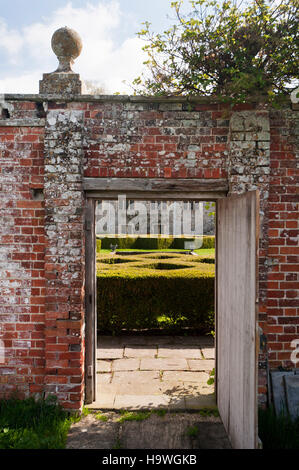 Vue à travers la cuisine jardin porte vers l'ouest face à Avebury Manor, dans le Wiltshire. Banque D'Images