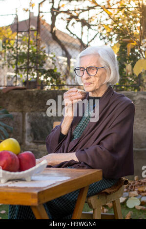 Senior woman having tasse de café en plein air Banque D'Images