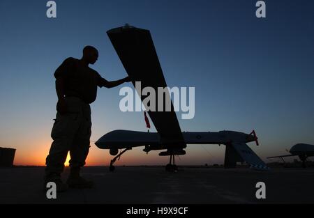 Des soldats américains inspecter un RQ-1 Predator drone au coucher du soleil après une mission aérienne pour l'opération Iraqi Freedom à la base aérienne de Balad, 15 septembre 2004 à Yathrib, l'Iraq. Banque D'Images