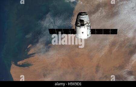 La Station spatiale internationale de la NASA, membre de l'équipage Expedition 41 L'astronaute allemand Alexander Gerst de l'Agence spatiale européenne capturé le SpaceX Dragon du fret commercial de plaisance près de l'ISS avec une vue satellite de l'Afrique dans l'arrière-plan le 23 septembre 2014 à partir de l'orbite de la Terre. Banque D'Images