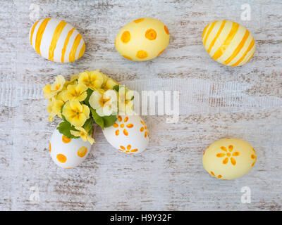Le blanc et le jaune des oeufs de pâques décorés et primrose composition fleurs Banque D'Images