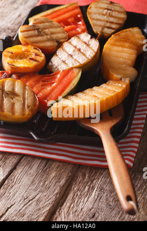 De délicieux fruits pommes, melon, poire, melon et pêche sur un gril gros plan sur la table verticale. Banque D'Images