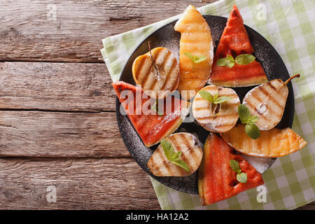 Pastèque, melon, poire, pomme et grillades de close-up sur une assiette. Vue du dessus horizontale Banque D'Images