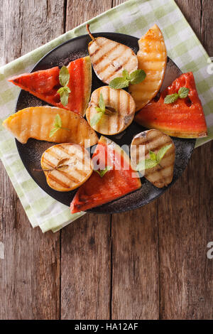 Pastèque, melon, poire, pomme et grillades de close-up sur une assiette. vertical Vue de dessus Banque D'Images