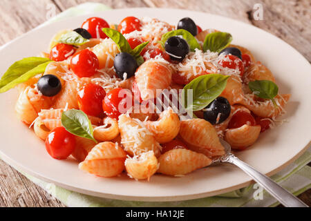 Pâtes aux tomates, olives et parmesan sur une plaque horizontale de près. Banque D'Images