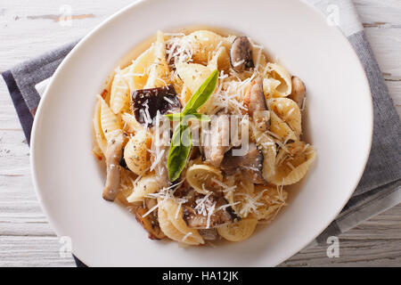 Cuisine italienne : Conchiglie aux cèpes et parmesan gros plan sur une assiette. Vue du dessus horizontale Banque D'Images