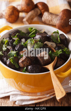 Poêlée de champignons sauvages avec les oignons et le persil dans une casserole close-up. La verticale Banque D'Images