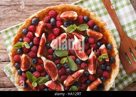 De délicieuses pâtisseries : tarte aux figues fraîches, les framboises et les bleuets close-up sur la table. Vue du dessus horizontale Banque D'Images