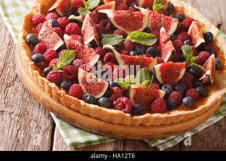 De délicieuses pâtisseries : tarte aux figues fraîches, les framboises et les bleuets close-up sur la table horizontale. Banque D'Images