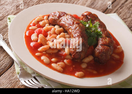 Saucisses grillées avec des haricots à la sauce tomate dans une assiette sur la table. L'horizontale Banque D'Images