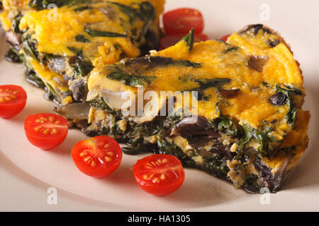 Frittata aux épinards et champignons sur une plaque horizontale de près. Banque D'Images