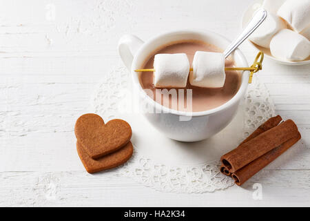 Tasse de cacao chaud boisson avec des bonbons sur la table en bois blanc Banque D'Images