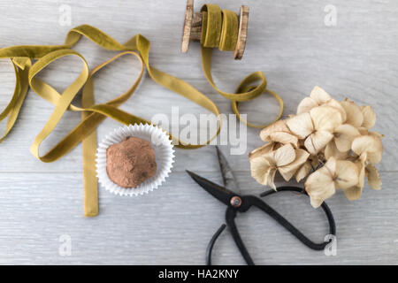 Avec une truffe au chocolat, fleurs sèches de hydrangea ciseaux et ruban Banque D'Images