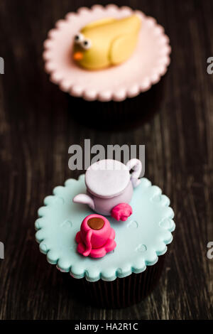 Cupcakes colorés avec mignon chiffres sur fond de bois Banque D'Images