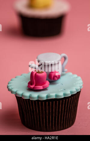 Cupcakes colorés avec mignon chiffres sur fond de bois de rose Banque D'Images
