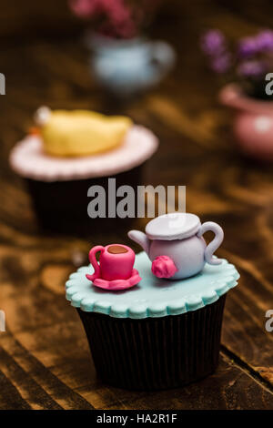 Cupcakes colorés avec mignon chiffres sur fond de bois Banque D'Images