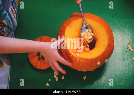 Fille dépose des semences d'un pumpkin Banque D'Images