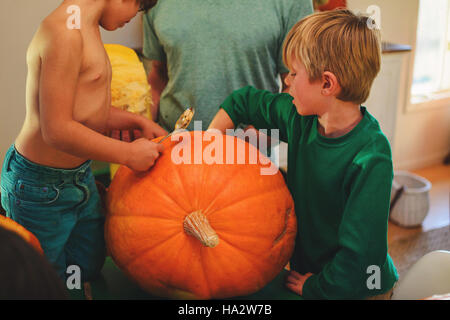 Son père et ses deux fils pour sculpter des citrouilles Halloween Banque D'Images