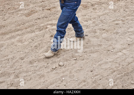 La section basse d'un homme qui marche en bottes de cow-boy Banque D'Images