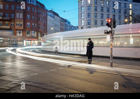 Les jeunes à la mode jeune homme attend sur le feu au crépuscule,Rosenthaler Platz,Berlin,German Banque D'Images