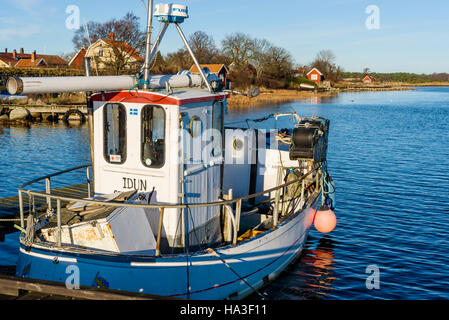 Kristianopel, Suède - 24 novembre 2016 : Voyage de Kristianopel documentaire à l'automne. Petit bateau de pêche dans le port avec des maisons et des hangars en arrière-plan. Banque D'Images