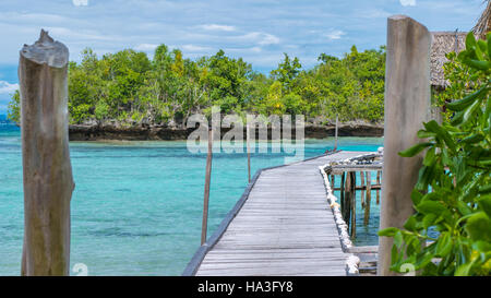 Pier de huttes de bambou, Kordiris Homestay, palmier à l'avant, l'île de Gam, les Papous, Raja Ampat, Indonésie Banque D'Images