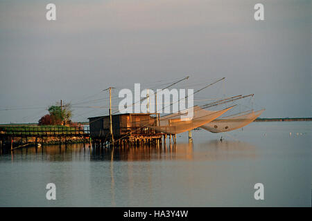 Valli di Comacchio, filets de pêche sur pilotis au crépuscule, Parc régional du Delta del po, Emilie Romagne, Italie Banque D'Images