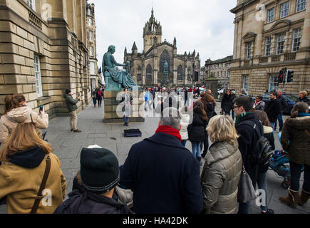 Les touristes regarder la statue du philosophe David Hume (1711 -1776) sur Edinburgh's Royal Mile. Banque D'Images