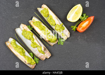 Les mactres navajas avec pesto de persil vert plaque en ardoise noire ona - Vue de dessus Banque D'Images
