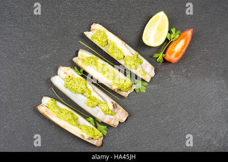 Les mactres navajas avec pesto de persil vert plaque en ardoise noire ona - Vue de dessus Banque D'Images